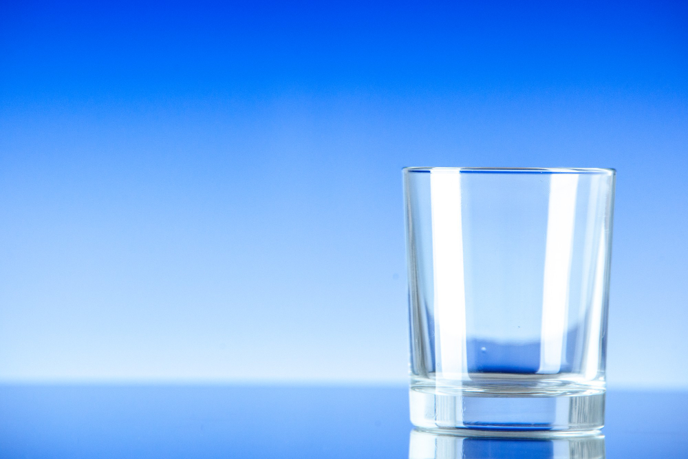 front-view-little-empty-glass-blue-surface